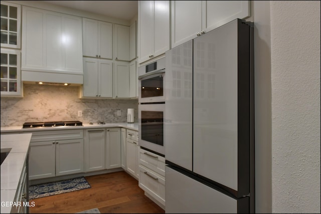 4490 Shadow Willow Dr, El Paso, TX 79922 - kitchen featuring white appliances, dark wood finished floors, light countertops, tasteful backsplash, and glass insert cabinets