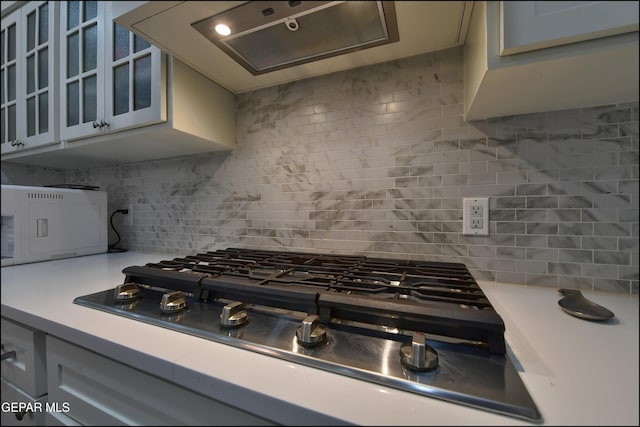 4490 Shadow Willow Dr, El Paso, TX 79922 - kitchen with stainless steel gas stovetop, light countertops, decorative backsplash, and glass insert cabinets