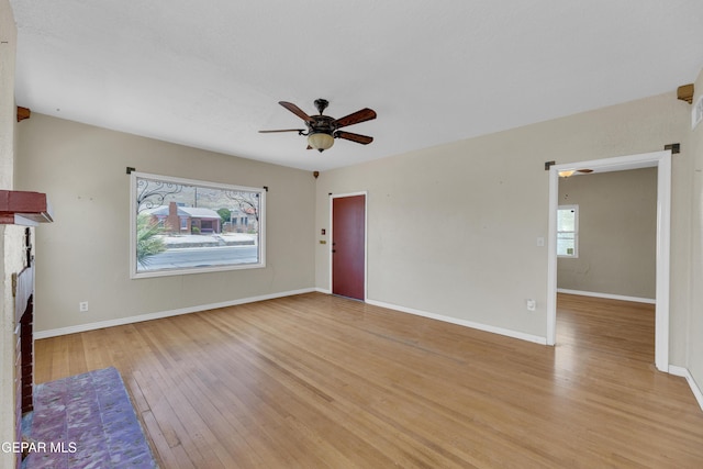 2312 Grant Ave, El Paso, TX 79930 - unfurnished living room featuring light wood-style floors, ceiling fan, baseboards, and a fireplace