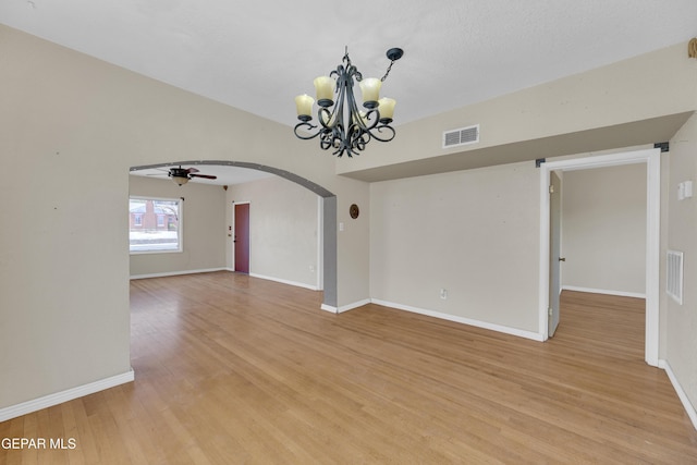 2312 Grant Ave, El Paso, TX 79930 - empty room featuring arched walkways, light wood-style floors, a ceiling fan, a chandelier, and baseboards