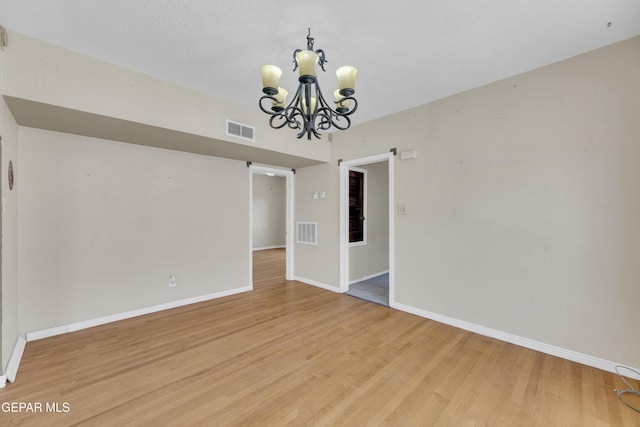 2312 Grant Ave, El Paso, TX 79930 - spare room with a chandelier, light wood-style flooring, and baseboards