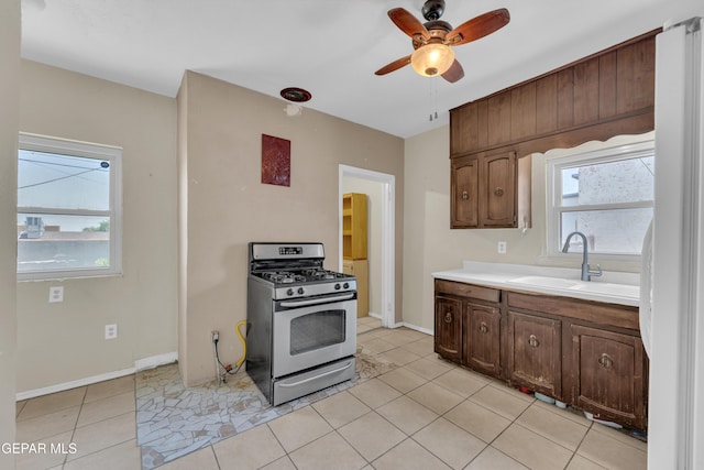 2312 Grant Ave, El Paso, TX 79930 - kitchen featuring stainless steel range with gas cooktop, a sink, light countertops, ceiling fan, and plenty of natural light