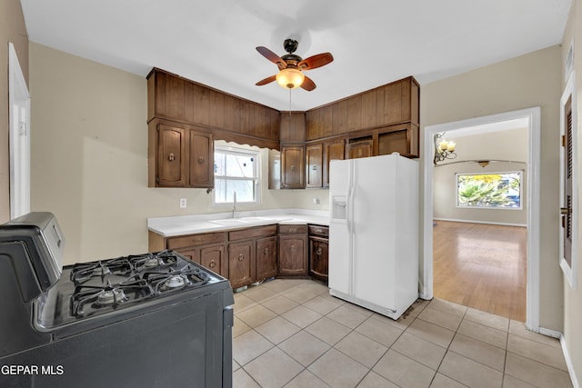 2312 Grant Ave, El Paso, TX 79930 - kitchen featuring white fridge with ice dispenser, range with gas cooktop, a sink, a ceiling fan, and light countertops