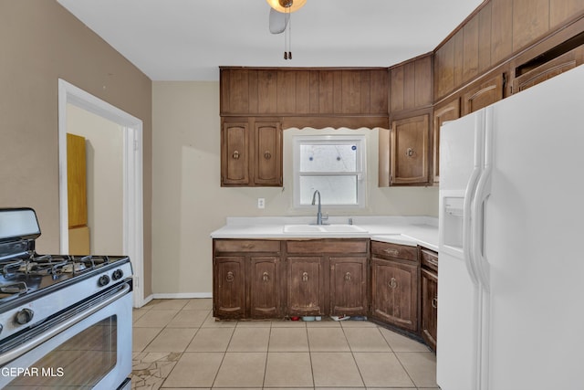 2312 Grant Ave, El Paso, TX 79930 - kitchen featuring white fridge with ice dispenser, stainless steel range with gas stovetop, a sink, and light countertops