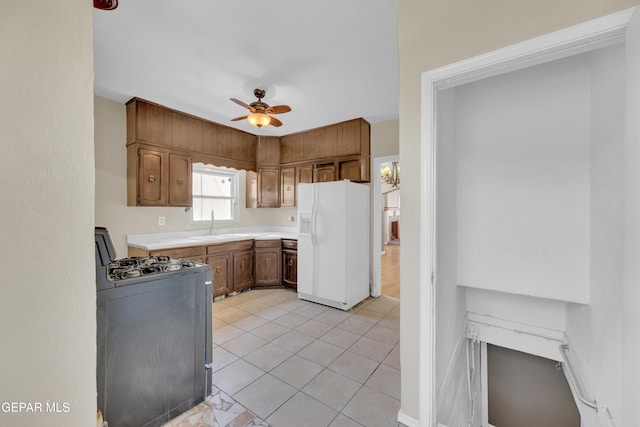 2312 Grant Ave, El Paso, TX 79930 - kitchen featuring white fridge with ice dispenser, range with gas cooktop, ceiling fan, light countertops, and light tile patterned floors