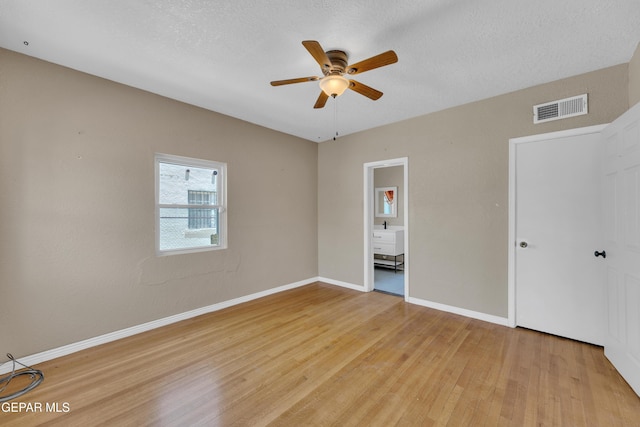 2312 Grant Ave, El Paso, TX 79930 - unfurnished bedroom featuring light wood-style flooring, baseboards, ceiling fan, and a textured ceiling