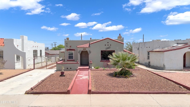 2312 Grant Ave, El Paso, TX 79930 - view of front of home with a gate, concrete driveway, stucco siding, and a tiled roof