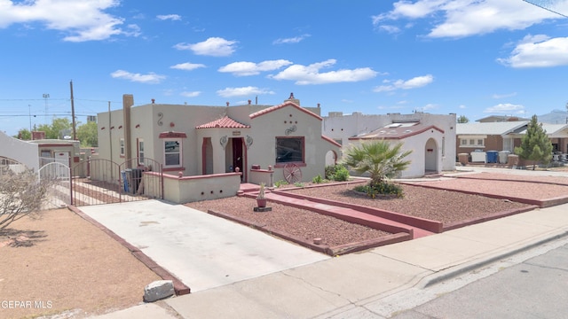 2312 Grant Ave, El Paso, TX 79930 - view of front of house featuring a gate, stucco siding, concrete driveway, a tiled roof, and a residential view
