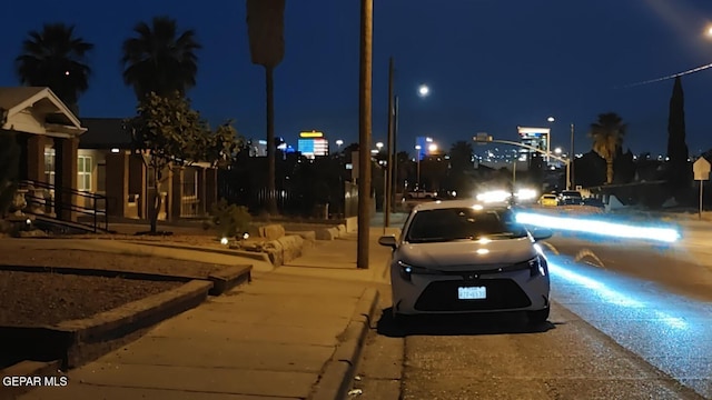 2312 Grant Ave, El Paso, TX 79930 - view of asphalt street with sidewalks, street lights, and curbs