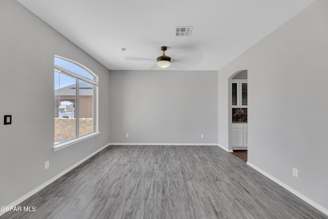14378 N Cave Dr, El Paso, TX 79938 - unfurnished room featuring ceiling fan, wood finished floors, arched walkways, and baseboards