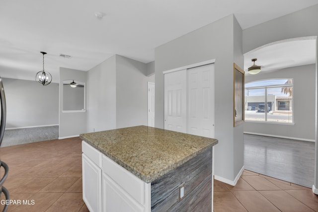 14378 N Cave Dr, El Paso, TX 79938 - kitchen featuring tile patterned floors, a ceiling fan, arched walkways, white cabinetry, and a kitchen island