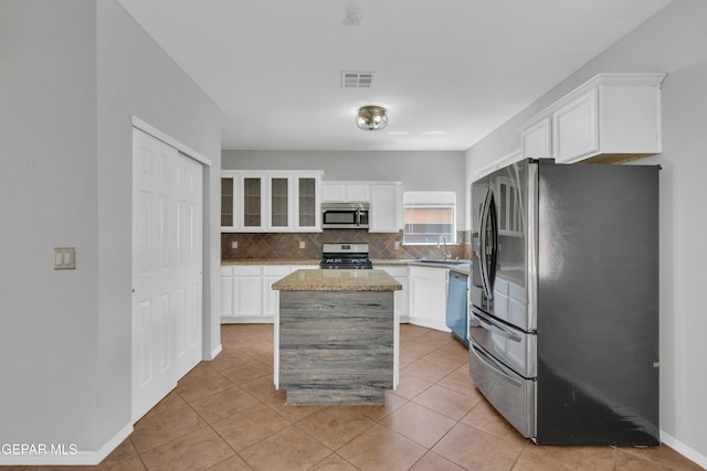 14378 N Cave Dr, El Paso, TX 79938 - kitchen with stainless steel appliances, a sink, decorative backsplash, white cabinets, and a kitchen island