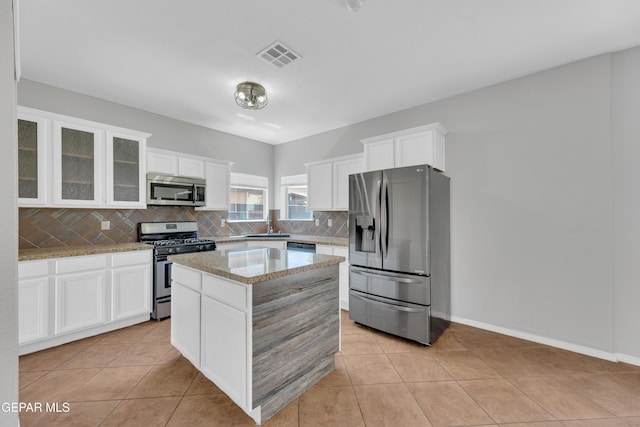 14378 N Cave Dr, El Paso, TX 79938 - kitchen with appliances with stainless steel finishes, backsplash, white cabinets, and light stone counters