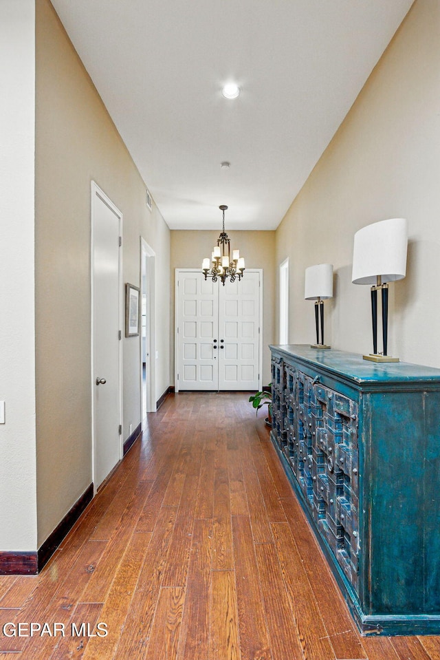 6006 Balcones Ct Unit 19, El Paso, TX 79912 - hall featuring a chandelier, hardwood / wood-style flooring, and baseboards
