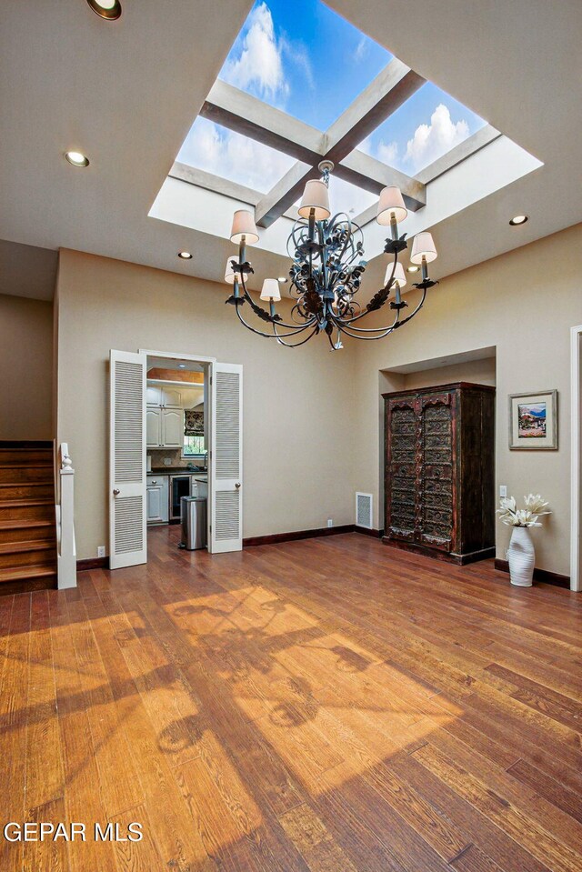 6006 Balcones Ct Unit 19, El Paso, TX 79912 - unfurnished living room featuring a skylight, wood finished floors, stairway, a chandelier, and recessed lighting