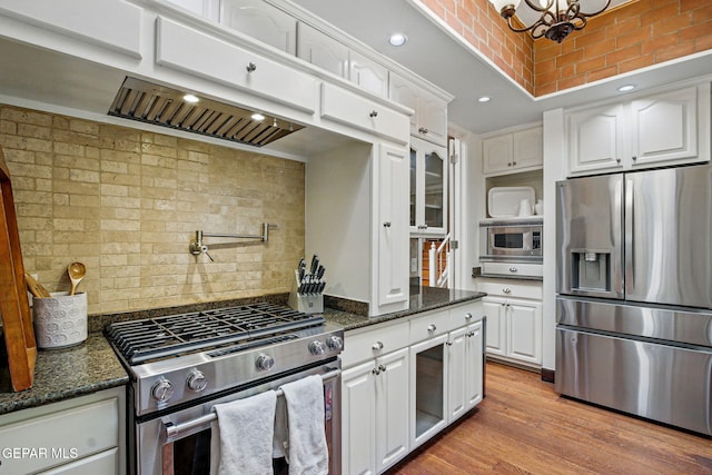 6006 Balcones Ct Unit 19, El Paso, TX 79912 - kitchen with appliances with stainless steel finishes, white cabinetry, dark stone counters, backsplash, and recessed lighting