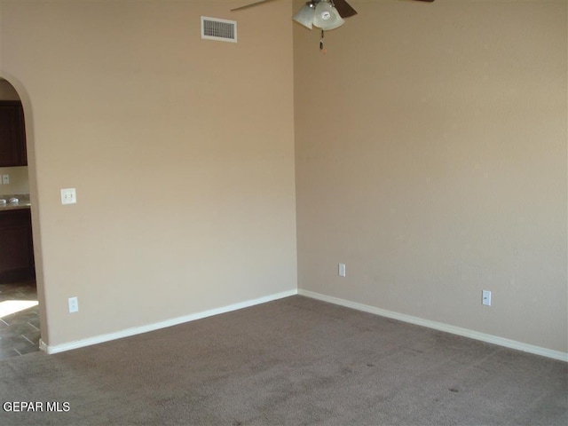 12036 Copper Hill Pl, El Paso, TX 79934 - empty room with ceiling fan, dark carpet, arched walkways, and baseboards