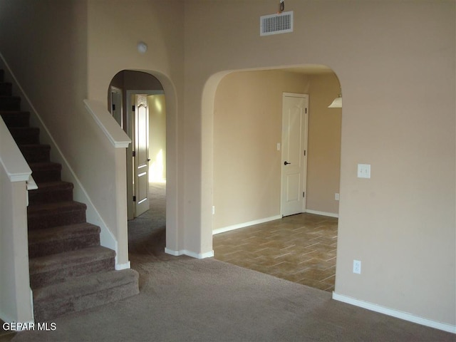 12036 Copper Hill Pl, El Paso, TX 79934 - carpeted empty room featuring arched walkways, stairs, baseboards, and a high ceiling
