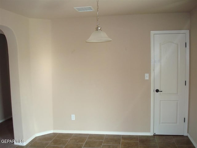 12036 Copper Hill Pl, El Paso, TX 79934 - unfurnished room featuring arched walkways, baseboards, and dark tile patterned flooring