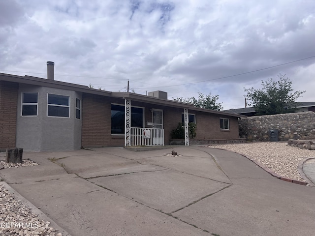 318 Olivia Cir, El Paso, TX 79912 - rear view of house with brick siding, covered porch, and concrete driveway