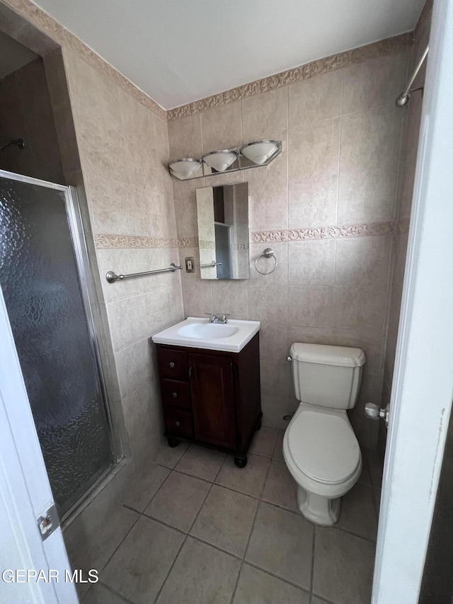 318 Olivia Cir, El Paso, TX 79912 - full bathroom featuring tile walls, a shower stall, vanity, toilet, and tile patterned flooring