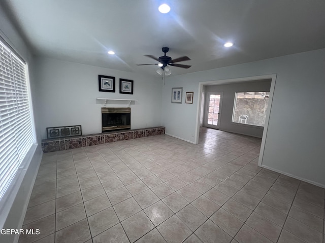318 Olivia Cir, El Paso, TX 79912 - unfurnished living room featuring tile patterned flooring, a ceiling fan, recessed lighting, a fireplace with raised hearth, and baseboards