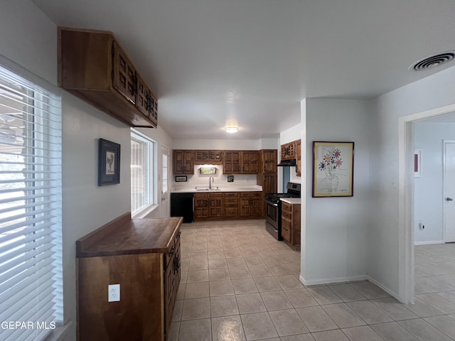 318 Olivia Cir, El Paso, TX 79912 - kitchen featuring gas stove, a sink, light tile patterned floors, dishwasher, and baseboards