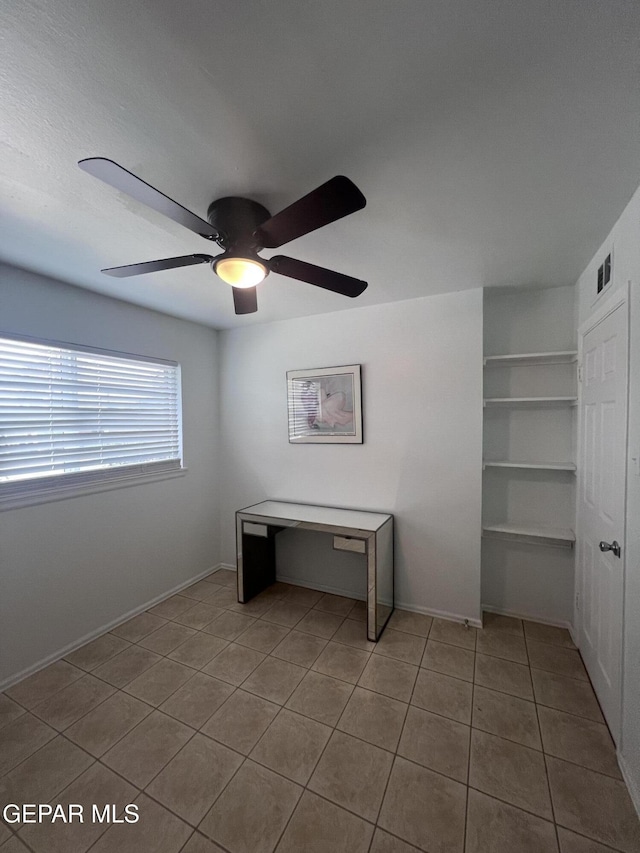 318 Olivia Cir, El Paso, TX 79912 - tiled empty room with a ceiling fan, built in shelves, and baseboards