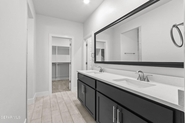 2232 Rocky Terrace Place, El Paso, TX 79911 - full bathroom with double vanity, wood finished floors, a walk in closet, and baseboards