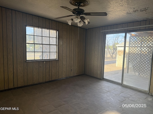 10385 Potencia Dr, Socorro, TX 79927 - unfurnished room featuring a ceiling fan, a textured ceiling, and wood walls