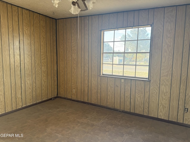 10385 Potencia Dr, Socorro, TX 79927 - unfurnished room featuring tile patterned floors, wood walls, and a ceiling fan