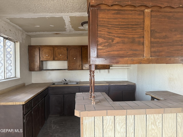10385 Potencia Dr, Socorro, TX 79927 - kitchen with a sink, tile counters, and stone finish flooring