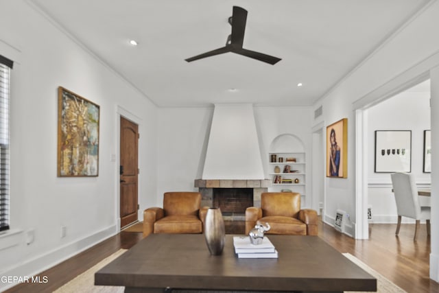 3100 Wheeling Ave, El Paso, TX 79930 - living room with built in shelves, a ceiling fan, wood finished floors, a fireplace, and baseboards