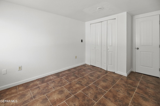 3100 Wheeling Ave, El Paso, TX 79930 - unfurnished bedroom with baseboards, a closet, and dark tile patterned flooring