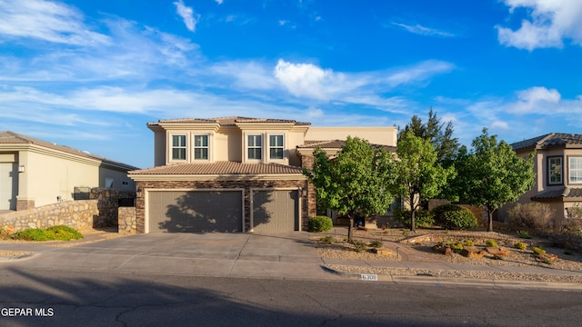 6308 Franklin Vis, El Paso, TX 79912 - view of front of house featuring driveway, an attached garage, a tiled roof, stucco siding, and stone siding