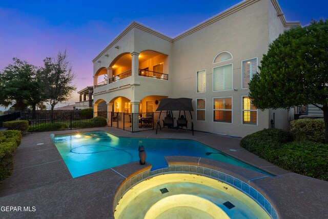 6308 Franklin Vis, El Paso, TX 79912 - rear view of house featuring a balcony, stucco siding, a patio, and a pool with connected hot tub