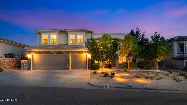 6308 Franklin Vis, El Paso, TX 79912 - view of front of house featuring an attached garage, a tiled roof, driveway, stucco siding, and stone siding