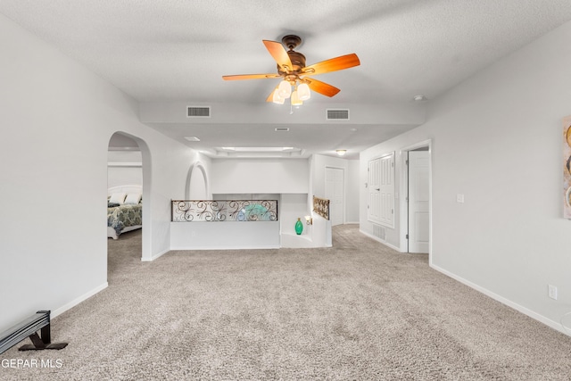 6308 Franklin Vis, El Paso, TX 79912 - unfurnished living room featuring carpet, ceiling fan, arched walkways, baseboards, and a textured ceiling