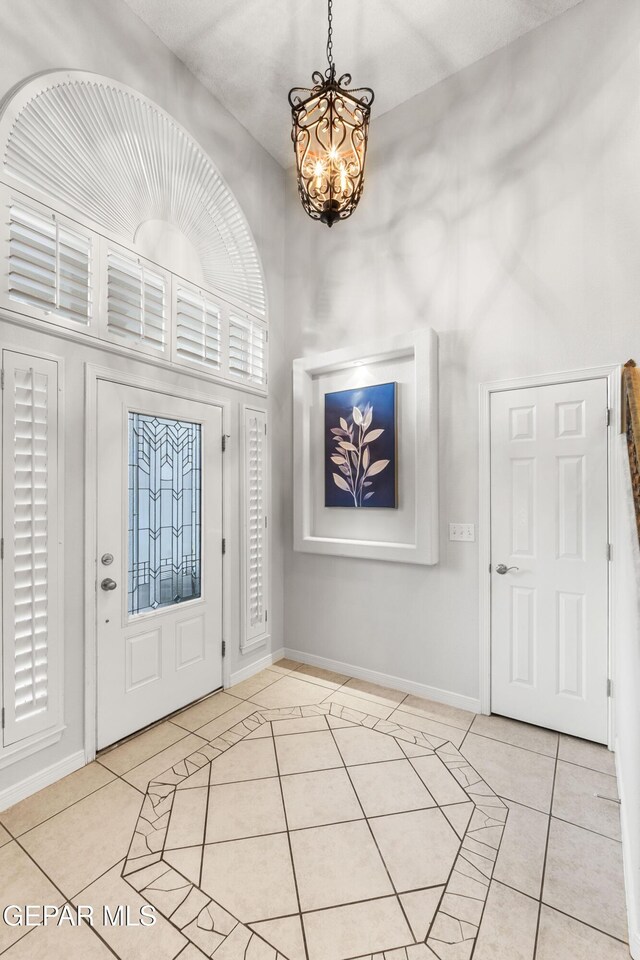 6308 Franklin Vis, El Paso, TX 79912 - foyer entrance with a chandelier, light tile patterned floors, and baseboards