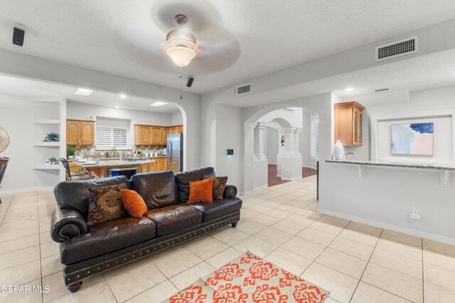 6308 Franklin Vis, El Paso, TX 79912 - living area with arched walkways, a ceiling fan, light tile patterned floors, and baseboards