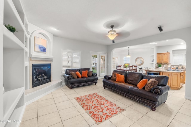 6308 Franklin Vis, El Paso, TX 79912 - living area featuring a ceiling fan, arched walkways, a fireplace, and light tile patterned floors