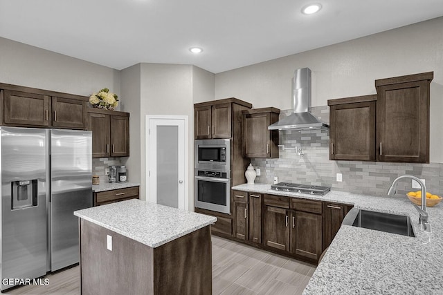 3936 Aspiration, El Paso, TX 79938 - kitchen featuring stainless steel appliances, wall chimney exhaust hood, a sink, dark brown cabinetry, and recessed lighting