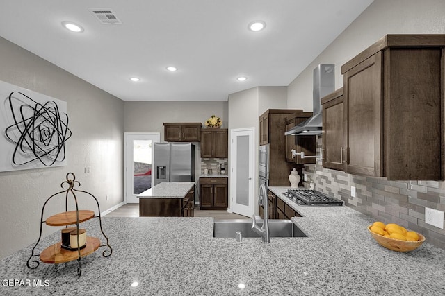 3936 Aspiration, El Paso, TX 79938 - kitchen with stainless steel appliances, tasteful backsplash, a sink, light stone countertops, and wall chimney exhaust hood