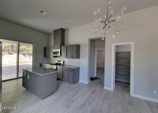 497 Plateau Dr, Socorro, TX 79927 - kitchen featuring stainless steel appliances, a chandelier, light wood-style flooring, decorative backsplash, and baseboards