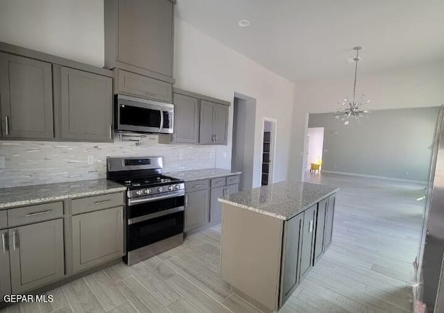 497 Plateau Dr, Socorro, TX 79927 - kitchen featuring appliances with stainless steel finishes, gray cabinets, light wood-style flooring, and tasteful backsplash
