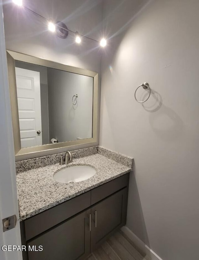 497 Plateau Dr, Socorro, TX 79927 - bathroom with vanity, wood finished floors, and baseboards