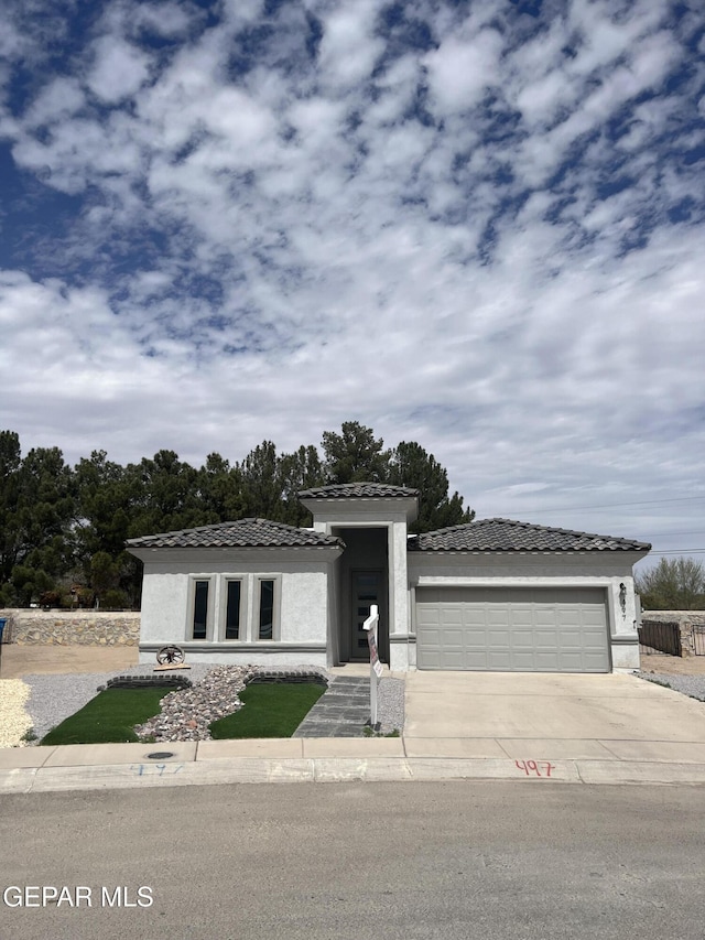 497 Plateau Dr, Socorro, TX 79927 - prairie-style house with an attached garage, concrete driveway, stucco siding, and a tile roof
