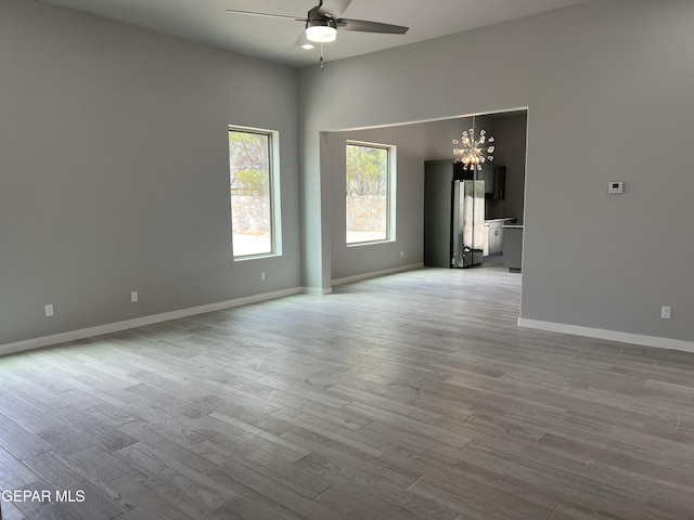 497 Plateau Dr, Socorro, TX 79927 - empty room with a ceiling fan, a chandelier, light wood-style flooring, and baseboards