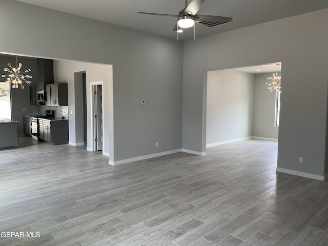 497 Plateau Dr, Socorro, TX 79927 - unfurnished living room featuring a chandelier, light wood-style floors, ceiling fan, and baseboards