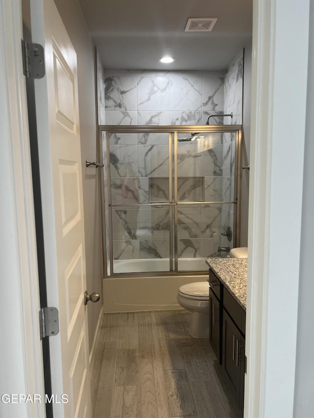 497 Plateau Dr, Socorro, TX 79927 - bathroom featuring toilet, vanity, wood finished floors, enclosed tub / shower combo, and recessed lighting